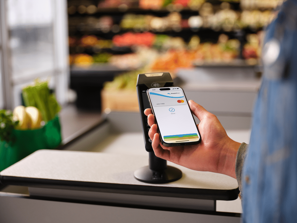 Contactless payments with SimpledCard Apple Pay on an iPhone at a point-of-sale terminal in a shop